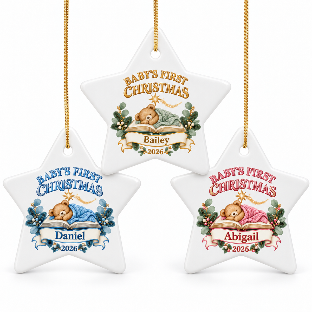 Three personalized white star-shaped Christmas ornaments hanging against a white background, each with a gold string and a teddy bear illustration. The ornaments feature different names and colors for the text and accents: 'Baby's First Christmas' in gold for Bailey, blue for Daniel, and pink for Abigail, with holly and ribbon details.