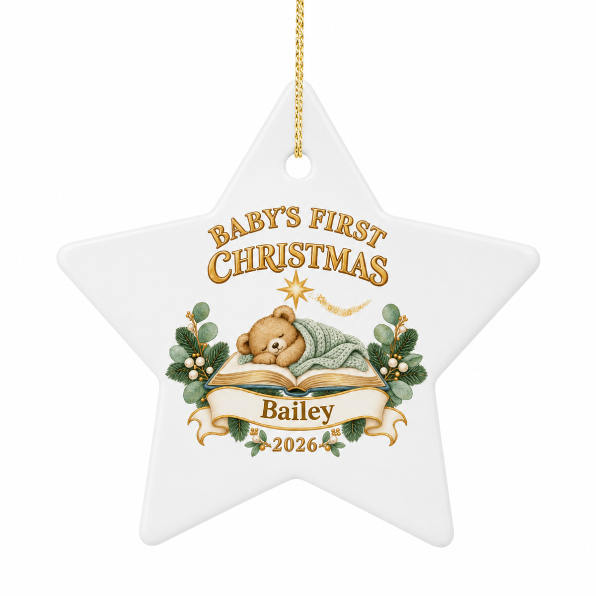 A white star-shaped Christmas ornament with a hanging loop, featuring a printed design for a baby's first Christmas. The design includes the text 'BABY'S FIRST CHRISTMAS' and 'Bailey 2026' with an illustration of a sleeping teddy bear under an open book, decorated with green holly leaves and gold accents.