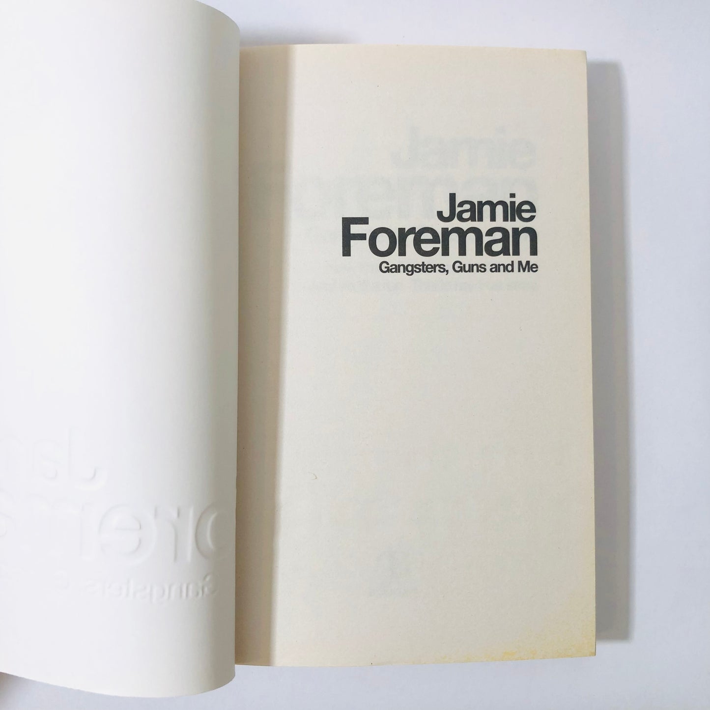 Book open to a page with 'Jamie Foreman' and 'Gangsters, Guns and Me' text on a white background