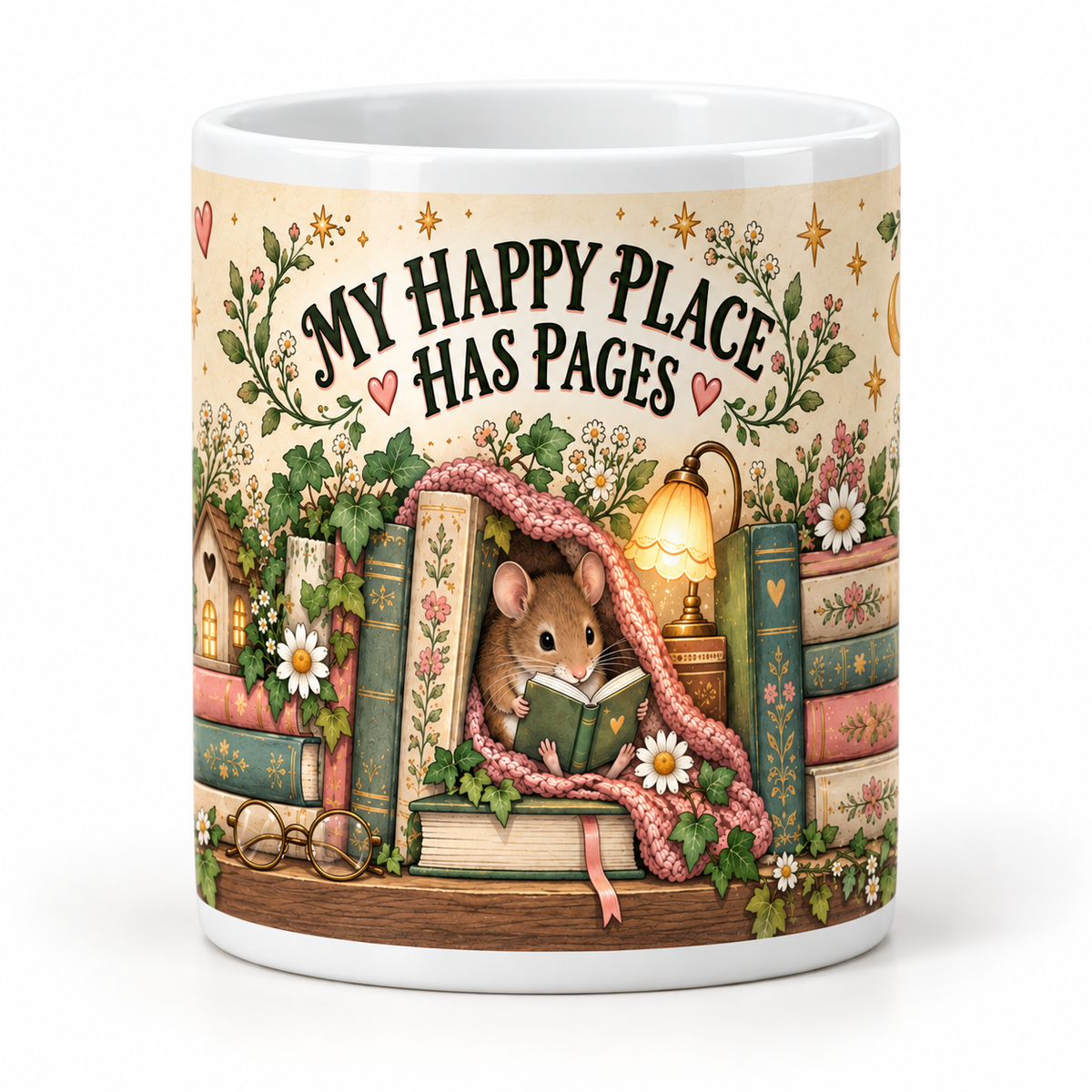 A white ceramic mug featuring a whimsical illustration of a small mouse reading under a pink blanket, surrounded by books, flowers, a birdhouse, and the text 'MY HAPPY PLACE HAS PAGES'.