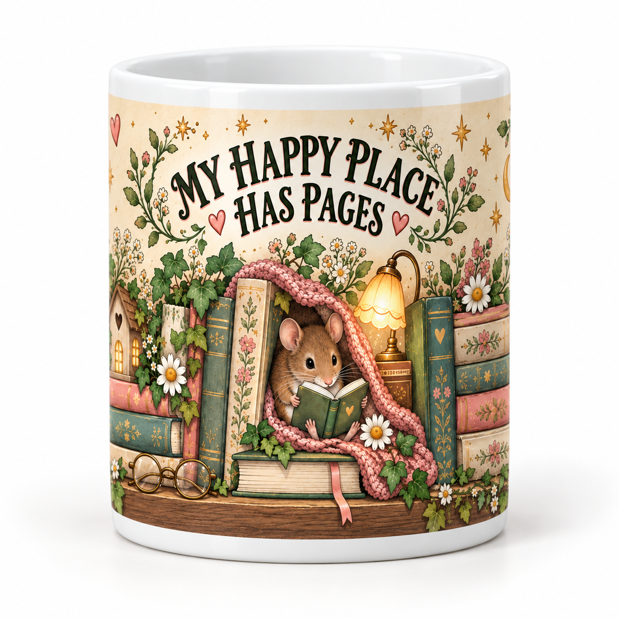 A white ceramic mug featuring a whimsical illustration of a small mouse reading under a pink blanket, surrounded by books, flowers, a birdhouse, and the text 'MY HAPPY PLACE HAS PAGES'.