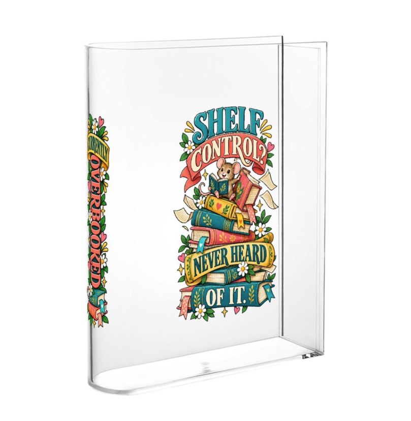 A clear acrylic book block or display stand holding a book with a colorful retro-style illustration on the cover. The cover features the text 'SHELF CONTROL' and 'NEVER HEARD OF IT' with a teddy bear sitting on stacked books and floral accents.