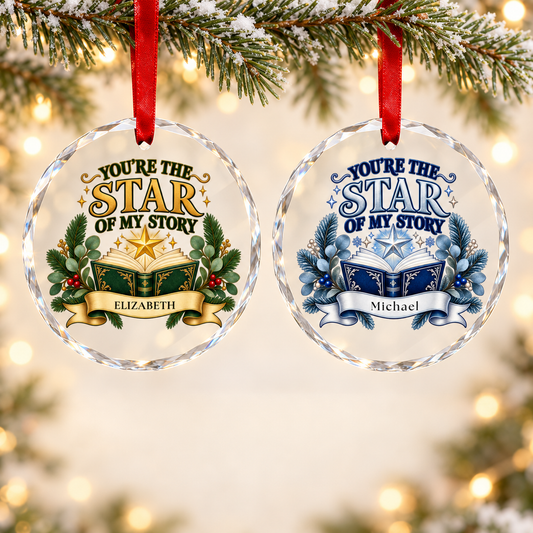 Two personalized round Christmas ornaments hanging from a snowy pine branch. One ornament is personalized for Elizabeth in green and gold, and the other for Michael in blue and silver.