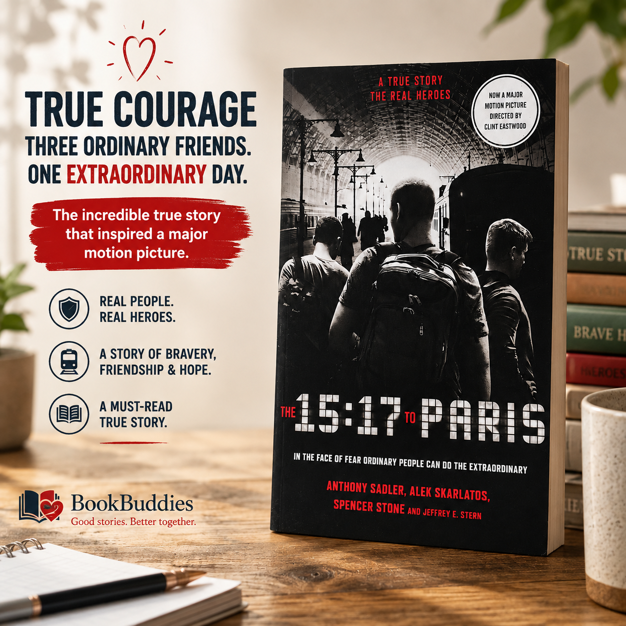A copy of The 15:17 to Paris by Anthony Sadler, Alek Skarlatos, Spencer Stone and Jeffrey E. Stern standing upright on a rustic wooden table in a warm, cosy reading space. The black-and-white cover with bold red accents is the main focus, surrounded by softly blurred houseplants, stacked books, a notebook and a coffee mug. Promotional text highlights the book as the inspiring true story behind the Clint Eastwood film, with BookBuddies branding in the bottom corner.
